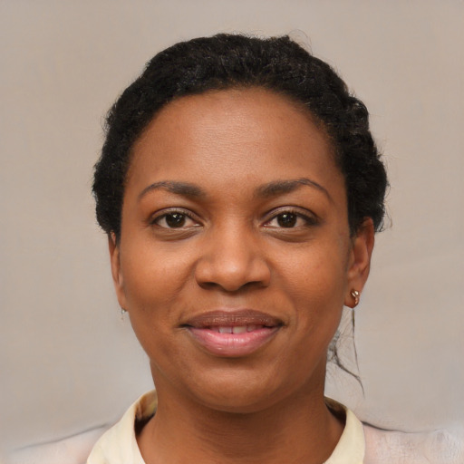 Joyful black young-adult female with short  black hair and brown eyes