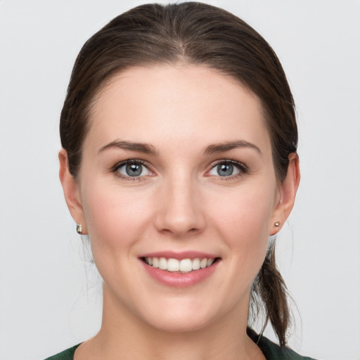 Joyful white young-adult female with medium  brown hair and grey eyes