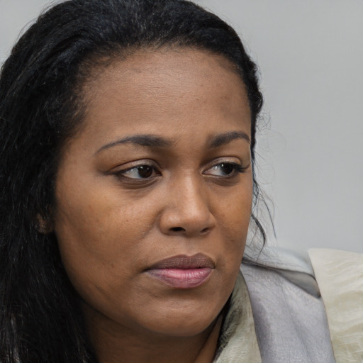 Joyful black young-adult female with long  brown hair and brown eyes