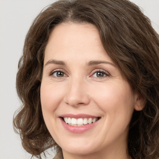 Joyful white young-adult female with medium  brown hair and green eyes