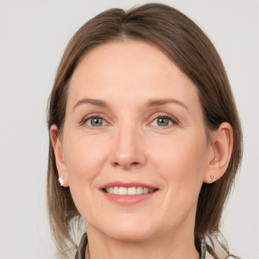 Joyful white adult female with long  brown hair and grey eyes