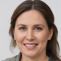 Joyful white adult female with medium  brown hair and grey eyes