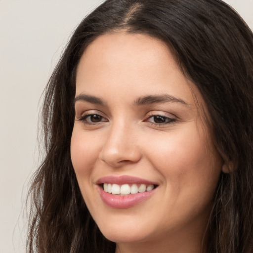 Joyful white young-adult female with long  brown hair and brown eyes