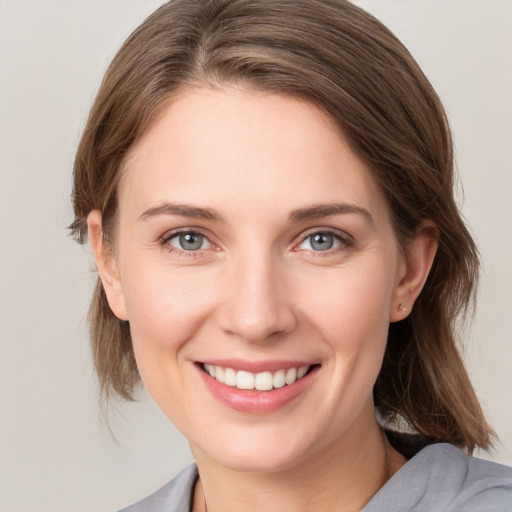 Joyful white young-adult female with medium  brown hair and grey eyes