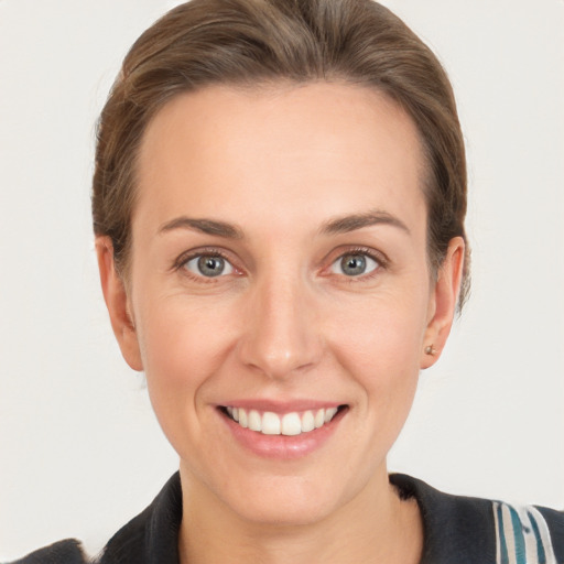 Joyful white young-adult female with short  brown hair and grey eyes