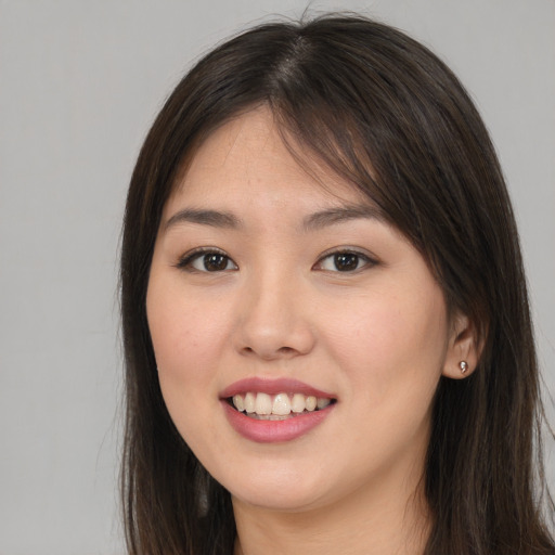 Joyful asian young-adult female with long  brown hair and brown eyes