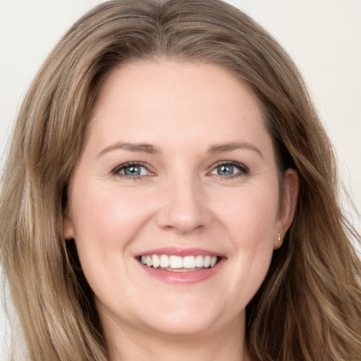 Joyful white young-adult female with long  brown hair and blue eyes