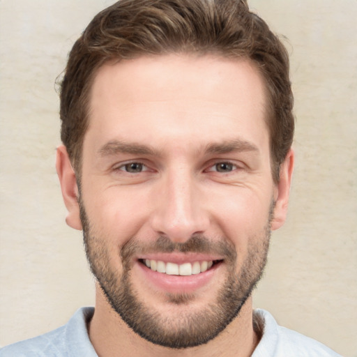 Joyful white young-adult male with short  brown hair and grey eyes