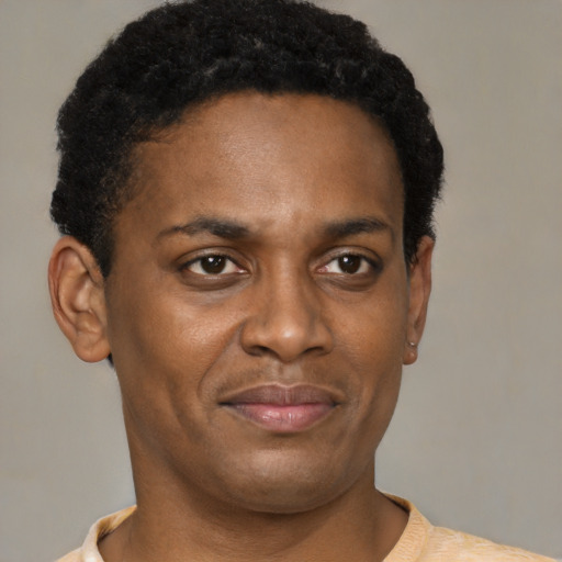 Joyful black young-adult male with short  brown hair and brown eyes