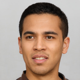 Joyful latino young-adult male with short  black hair and brown eyes
