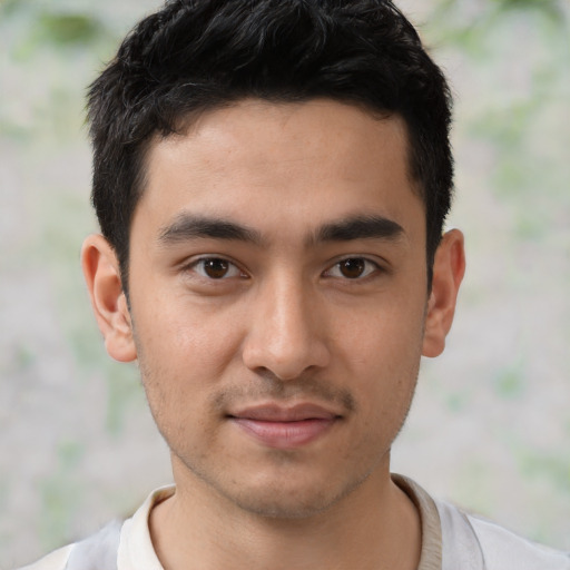 Joyful latino young-adult male with short  brown hair and brown eyes