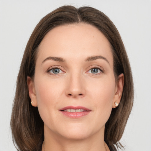 Joyful white young-adult female with medium  brown hair and grey eyes