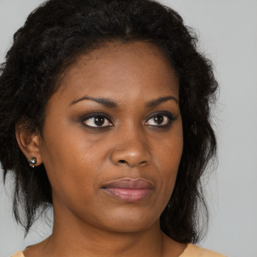 Joyful black young-adult female with medium  brown hair and brown eyes