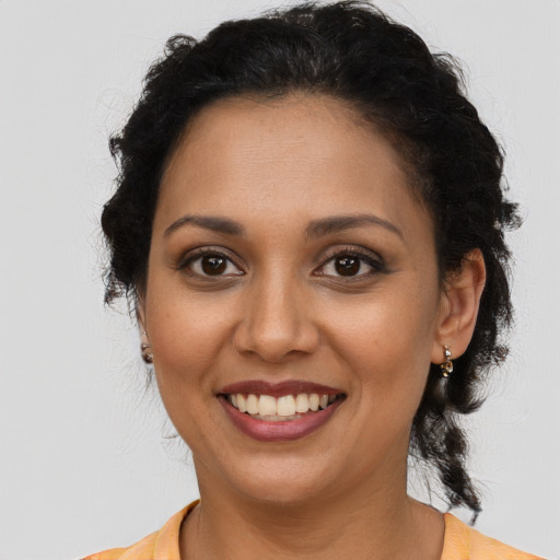 Joyful latino adult female with medium  brown hair and brown eyes