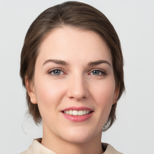 Joyful white young-adult female with medium  brown hair and grey eyes