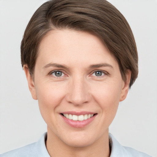 Joyful white young-adult female with short  brown hair and grey eyes