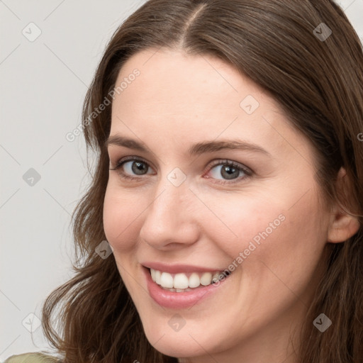 Joyful white young-adult female with long  brown hair and grey eyes