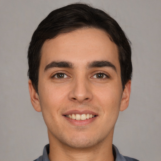 Joyful white young-adult male with short  black hair and brown eyes