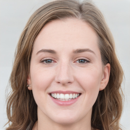 Joyful white young-adult female with long  brown hair and grey eyes