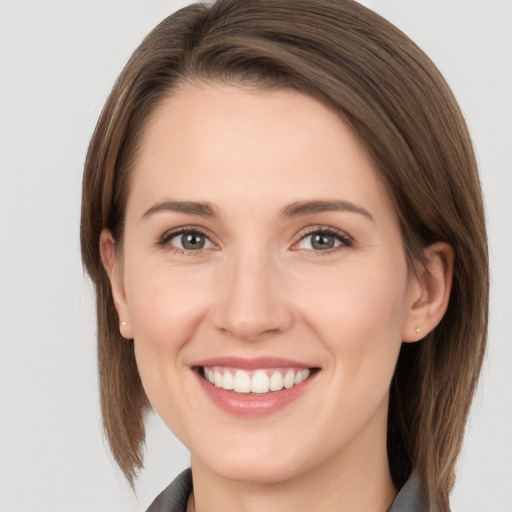 Joyful white young-adult female with medium  brown hair and grey eyes