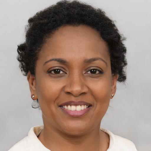 Joyful black young-adult female with short  brown hair and brown eyes