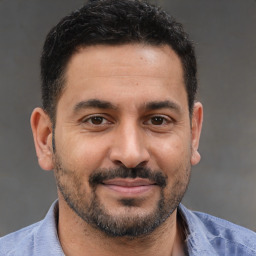 Joyful latino adult male with short  brown hair and brown eyes