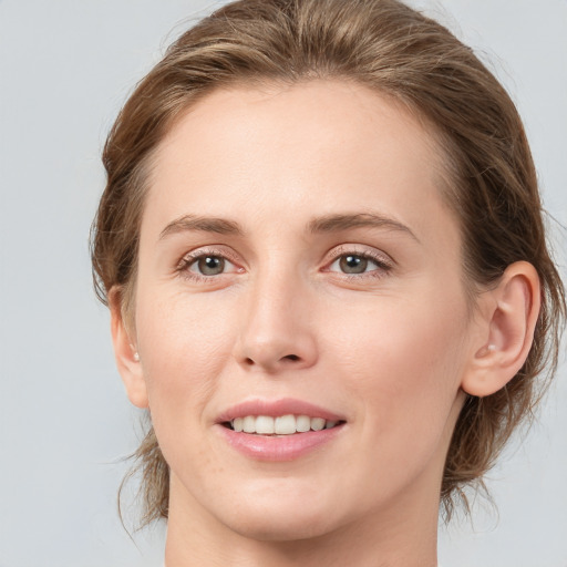 Joyful white young-adult female with medium  brown hair and grey eyes