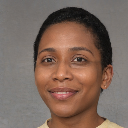 Joyful black young-adult female with short  black hair and brown eyes