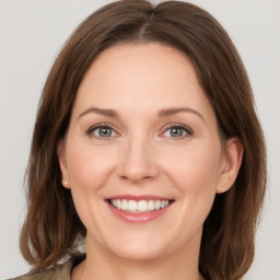 Joyful white young-adult female with medium  brown hair and green eyes