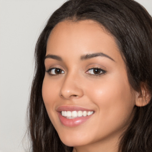 Joyful latino young-adult female with long  brown hair and brown eyes