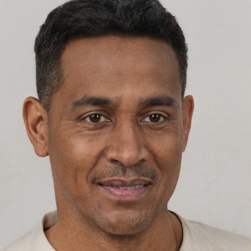 Joyful latino adult male with short  brown hair and brown eyes