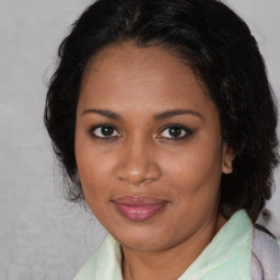 Joyful black young-adult female with medium  brown hair and brown eyes