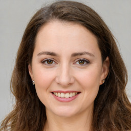 Joyful white young-adult female with long  brown hair and green eyes