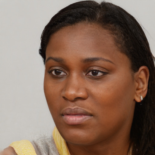 Joyful black young-adult female with long  brown hair and brown eyes