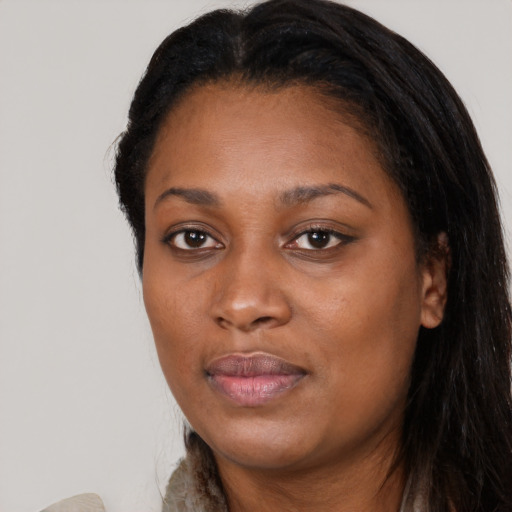 Joyful black young-adult female with long  brown hair and brown eyes