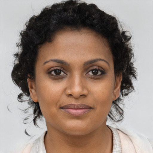 Joyful black young-adult female with long  brown hair and brown eyes
