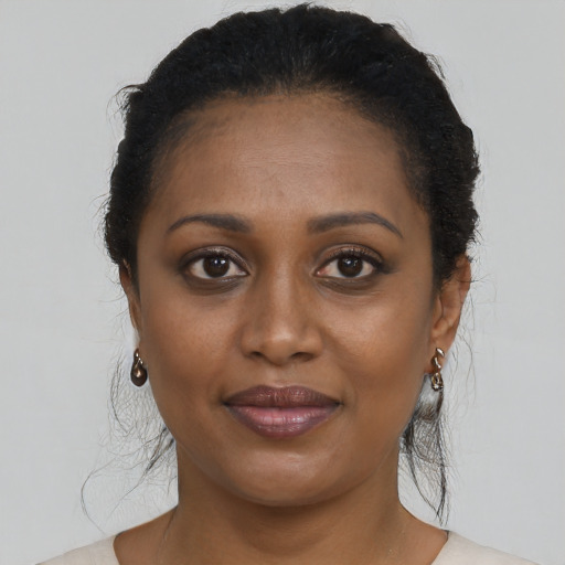Joyful black young-adult female with medium  brown hair and brown eyes