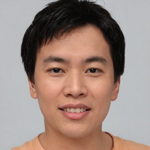 Joyful asian young-adult male with short  black hair and brown eyes