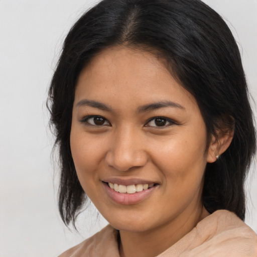 Joyful latino young-adult female with medium  brown hair and brown eyes
