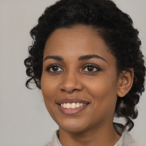 Joyful black young-adult female with medium  black hair and brown eyes