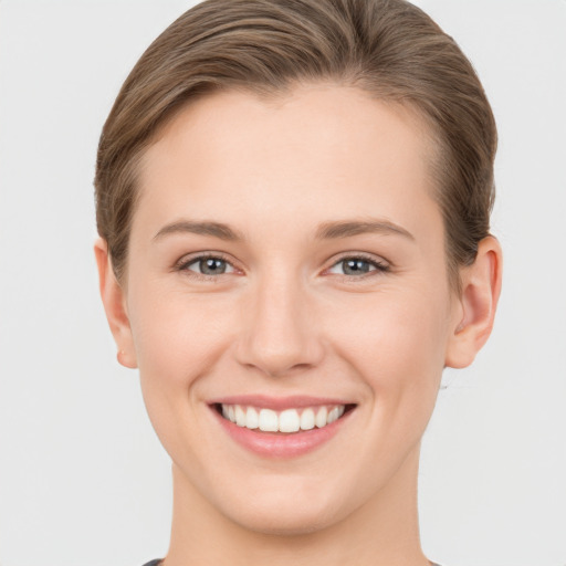 Joyful white young-adult female with short  brown hair and grey eyes