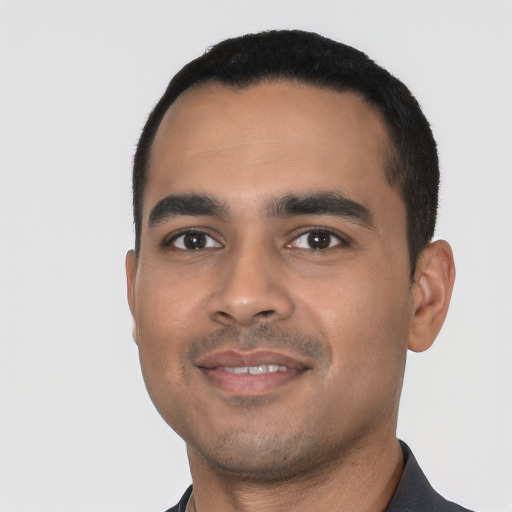 Joyful latino young-adult male with short  black hair and brown eyes
