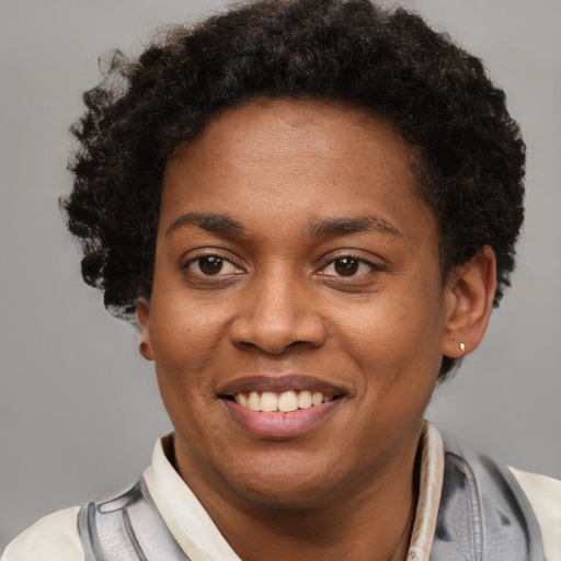 Joyful black young-adult female with short  brown hair and brown eyes