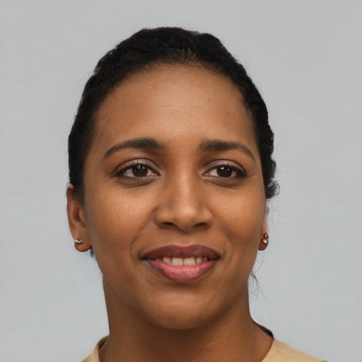 Joyful black young-adult female with short  black hair and brown eyes