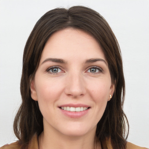 Joyful white young-adult female with long  brown hair and grey eyes