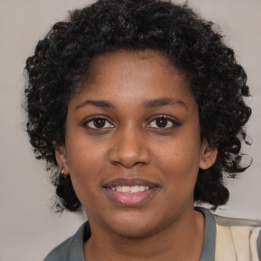Joyful black young-adult female with long  black hair and brown eyes