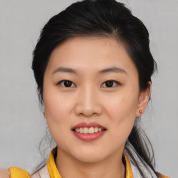 Joyful asian young-adult female with medium  brown hair and brown eyes