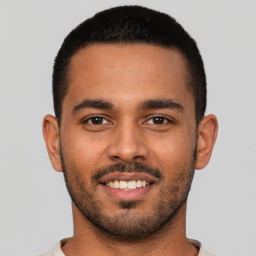 Joyful latino young-adult male with short  brown hair and brown eyes