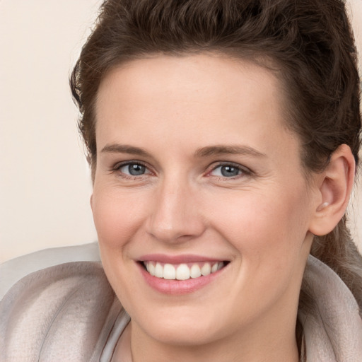 Joyful white young-adult female with long  brown hair and grey eyes