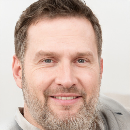 Joyful white adult male with short  brown hair and grey eyes